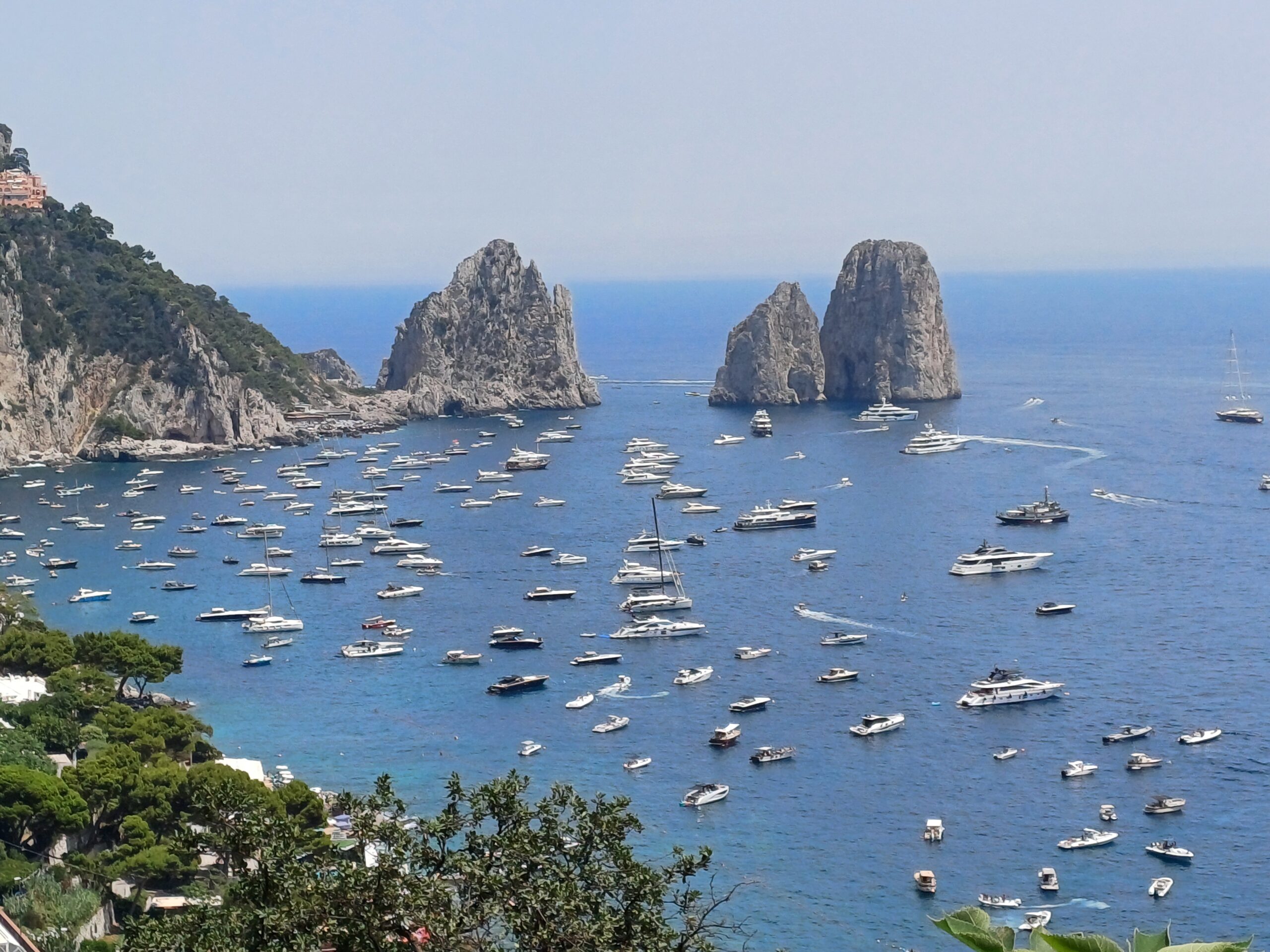 Tutti a mare! Distesa di barche a Capri davanti ai Faraglioni (video)