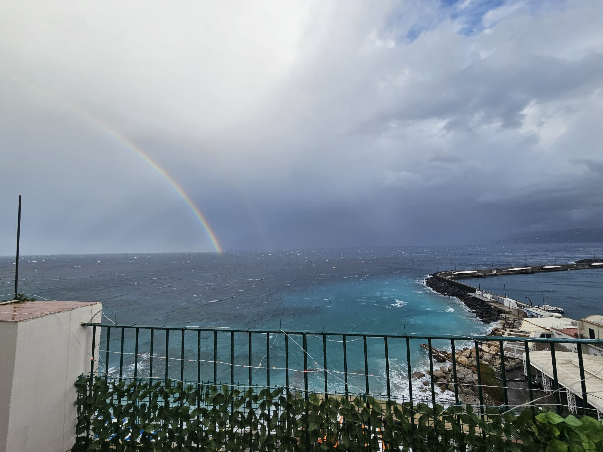 L’arcobaleno dell’Immacolata a Capri sul mare increspato